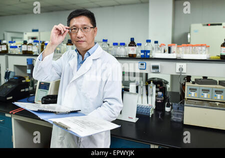 (150522)--Peking, 22. Mai 2015 (Xinhua)--Lu Xianping arbeitet in einem Labor in Shenzhen Chipscreen Biosciences Ltd in Shenzhen, Guangdong Provinz Süd-China, 20. Mai 2015. Lu Xianping war zusammen mit anderen vier zurückgegebenen ausländischen Wissenschaftlern, 14 Jahre, Chidamide, die weltweit erste mündliche HDAC Inhibitor, entwickeln die Zulassung im Januar erhielt. (Xinhua/Mao Siqian) (Zkr) Stockfoto