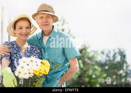 Porträt des Lächelns älteres Paar mit Blumen Stockfoto