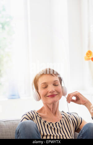 Lächelnde ältere Frau mit Kopfhörern Stockfoto