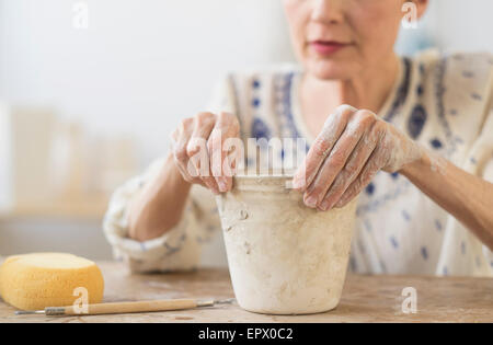 Ältere Frau macht Blumentopf in Werkstatt Stockfoto