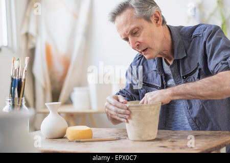 Ältere Frau macht Blumentopf in Werkstatt Stockfoto