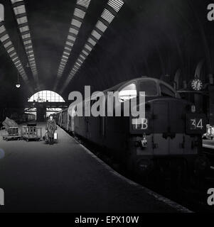 1950er-Jahren, historische, haben eine gut gekleidete Dame eine leere Plattform hinunter, Bahnhof Paddington, London, gerade begonnen aus einer inter-City-Zug. Stockfoto