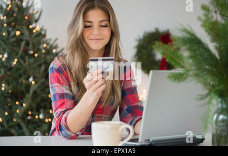 Junge Frau mit Kreditkarte beim Online-shopping Stockfoto