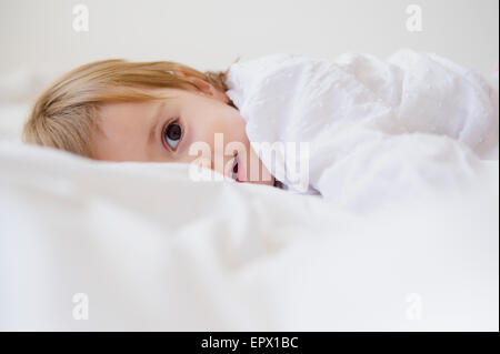 Mädchen (2-3) auf Bett liegend Stockfoto