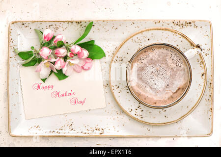Heiße Schokolade mit Blumen und Greetimgs Karte. Kakaogetränk mit Milchschaum. Schönen Muttertag! Stockfoto