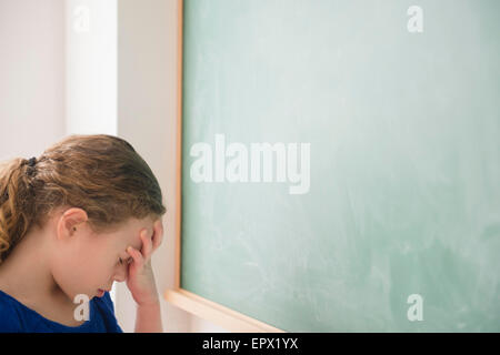 Mädchen tun Gesicht Palm vor der grünen Tafel Stockfoto