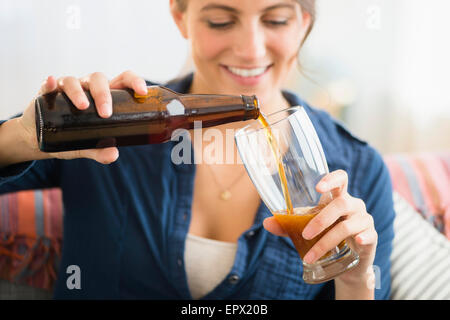 Frau gießt Bier Stockfoto