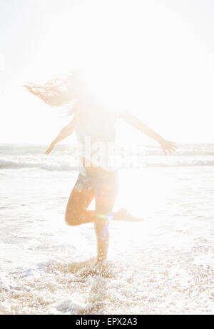 Frau, Jupiter, Florida, USA stehen auf einem Bein im Meer Stockfoto