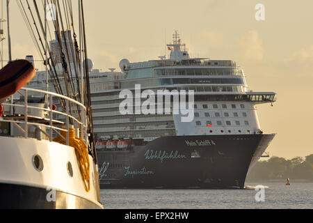 Kreuzfahrtschiff "Mein Schiff 4" vorbei an einem traditionellen Segelschiff in der frühen Morgensonne. Stockfoto