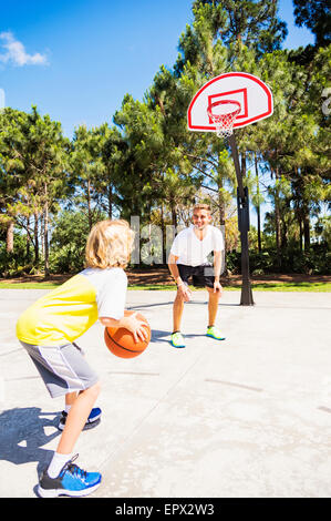 Jungen (8-9) Basketball spielen mit seinem Bruder Stockfoto