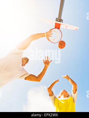 Jungen (8-9) Basketball spielen mit seinem Bruder Stockfoto