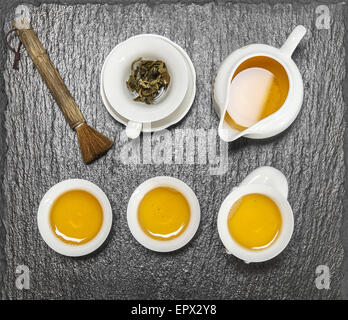 Teekanne und weiße Tassen am Steintisch. Utensilien für die traditionellen chinesischen Tee-Zeremonie. Ansicht von oben Stockfoto