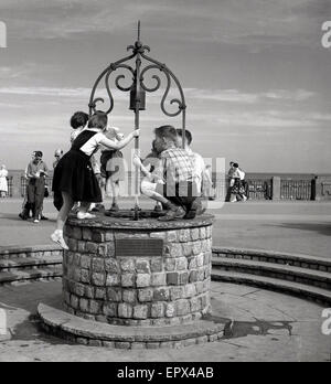 1950er-Jahren, historische, promenade Kinder spielen auf der Oberseite einen Wunschbrunnen, direkt am Meer, Douglas, Isle Of Man, Stockfoto