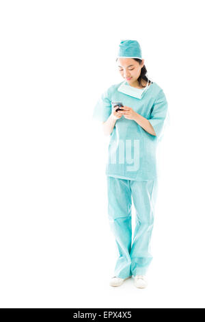 Asiatische Frauen Chirurg von SMS-Nachrichten auf dem Handy Stockfoto