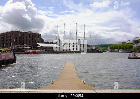 Ein Holzsteg erstreckt sich in Richtung der Masten der SS GReat Britain in Bristol Hafen. Stockfoto