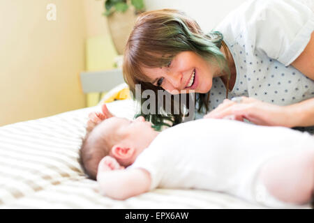 Lächelnde Mutter liegen auf schlecht mit Baby (6-11 Monate) Stockfoto