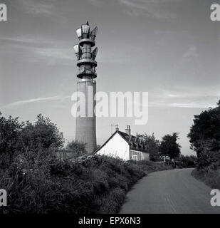 1950er-Jahren, historische, einer ruhigen Landstrasse zeigt eine BT-Telekommunikation oder Funkturm mit Mikrowellen-Antennen und frühen Satelliten-Receiver an der Spitze. Stockfoto