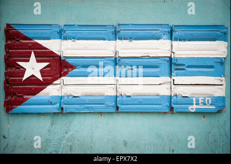 Havanna, Kuba - Juni 2011: Kubanische Flagge gemalt auf der Oberfläche der Hardware auf einer blauen Wand in Alt-Havanna. Stockfoto