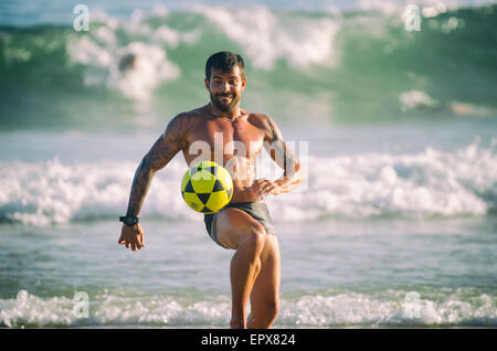 RIO DE JANEIRO, Brasilien - 28. Januar 2014: Muskulösen jungen brasilianischen Mann eine Partie Altinho keepy spielt uppy Posto 9 in Ipanema Stockfoto