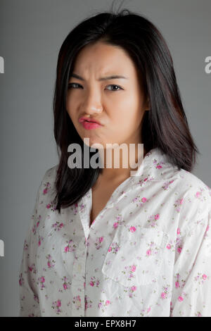 Attraktive asiatische Mädchen in ihren Zwanzigern isoliert auf Plein Hintergrund in einem Studio gedreht Stockfoto