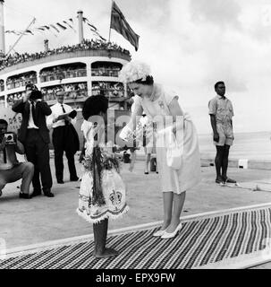 Königin Elizabeth II kommt in Suva, Fidschi-Inseln von der Royal Yacht und präsentiert einen Blumenstrauß von Fidschi Mädchen Adi Kaunilotuma, die vor ihr auf dem Teppich während des königlichen Besuchs nach Fidschi, Februar 1963 setzte. Stockfoto