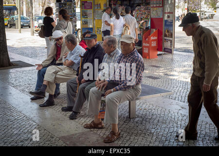 Gruppe von Reife lokalen portugiesischen Männer sitzen auf einer Bank in der Straße im Chat Stockfoto