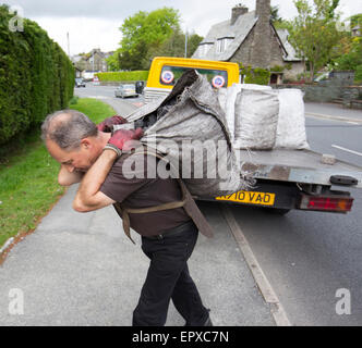 traditionelle Kohle Mann Lieferung offene Säcke Kohle aus LKW Stockfoto