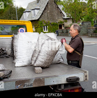 traditionelle Kohle Mann Lieferung offene Säcke Kohle aus LKW Stockfoto