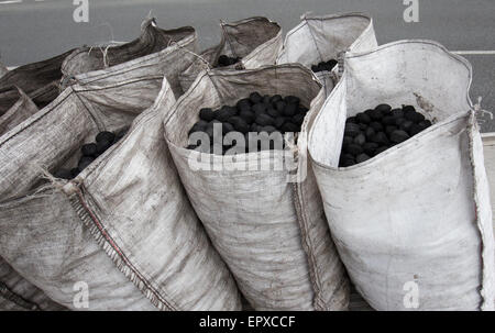 traditionelle Kohle Mann Lieferung offene Säcke Kohle aus LKW Stockfoto