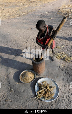 South Sudan Rumbek, Cuibet, Dinka junge bereitet Mehl aus Sorghum Samen Stockfoto