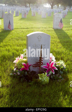 San Antonio, TX, USA. 22. Mai 2015. Eine amerikanische Flagge und Blumen platziert auf einer Grabstätte mit anderen Flags gesetzt von Freiwilligen in Vorbereitung für Memorial Day in Fort Sam Houston National Cemetery in San Antonio, Texas, USA. Der Friedhof beherbergt jährliche Gedenkfeier Aktivitäten für Memorial Day, die diejenigen erinnert verstorbenen dienen der US-Streitkräfte. Bildnachweis: Michael Silber Reisen & Unterhaltung/Alamy Live-Nachrichten Stockfoto