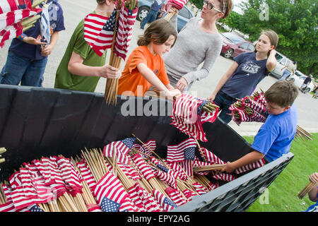 Freiwillige sammeln amerikanische Flaggen während der Memorial Day Vorbereitungen in Fort Sam Houston National Cemetery in Grabstätten stellen Stockfoto