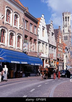 Pferdekutsche Kutsche entlang Wollestraat mit dem Belfried nach hinten, Brügge, Belgien, West-Europa. Stockfoto