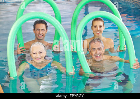 Gruppe von Senioren mit Nudeln schwimmen in einem Schwimmbad Stockfoto