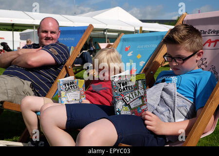 Hay-Festival, Powys, Wales - Mai 2015 - The Harris Familie gereist von Nottingham, das diesjährige Hay Festival zu besuchen. Die beiden jungen sind damit beschäftigt, Baureihe Tom Gates geschrieben von Childrens Autorin Liz Pichon und ihrem Webinar im Laufe des Tages zu lesen. Stockfoto