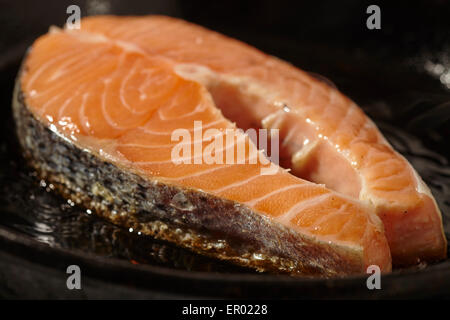 Lachssteak in einer gusseisernen Pfanne braten Stockfoto