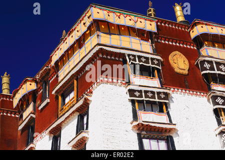 Weiß getünchte Wände vergoldet und hölzerne Dhvajas vergoldet Rondelle. Potala-Palast mit Potrang Karpo-Marpo rot-weißen Palästen. Lhasa. Stockfoto