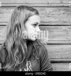 Schöne blonde kaukasische Mädchen Teenager, Nahaufnahme outdoor Portrait über ländliche Holzwand Stockfoto