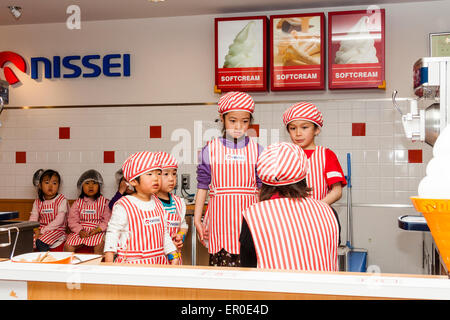 Kinderaktivitätszentrum Kidzania in Nishinomiya, Japan. Gruppe von Kindern lernen, wie man Eis mit Lehrer helfen zu machen und zu dekorieren. Stockfoto