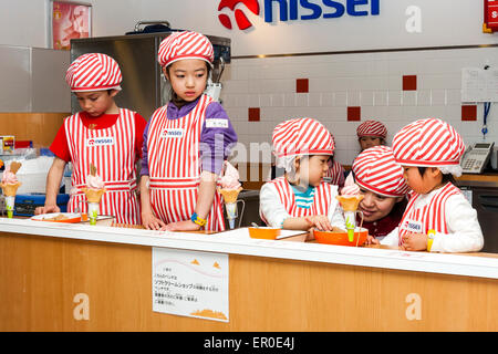 Kinderaktivitätszentrum Kidzania in Nishinomiya, Japan. Gruppe von Kindern lernen, wie man Eis mit Lehrer helfen zu machen und zu dekorieren. Stockfoto