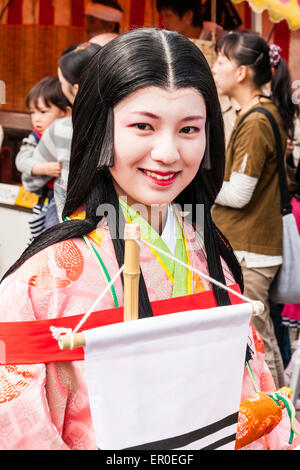 Genji Parade bei Tada in Japan. Lächelnde junge Japanerin, in Heian-Kostüm, Kazami, einer Adligen, die vorbeigeht und den Betrachter anschaut. Stockfoto