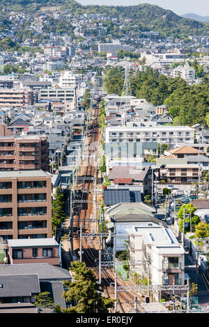 Luftaufnahme der Hankyu-Eisenbahnlinie von Shukugawa in Nishinomiya, Japan, zum Bahnhof Kōyōen. Dicht besiedelte städtische Szene. Stockfoto