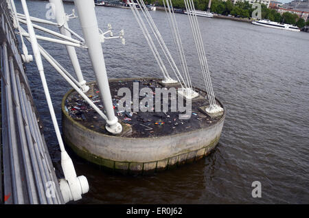 London, UK, 9. Mai 2014, Skateboard Friedhof von Skatern, die häufig gesucht Bank auf eine Ost-Seitenhalt Hungerford Bridge zwischen Charing Cross Station Royal Festival Hall.It ist spontane Denkmal aus Mord 24 jährigen Skateboarder Timothy Baxter 1999.Old gebrochen Skateboards Trainer über Brücke geworfen werden. Stockfoto