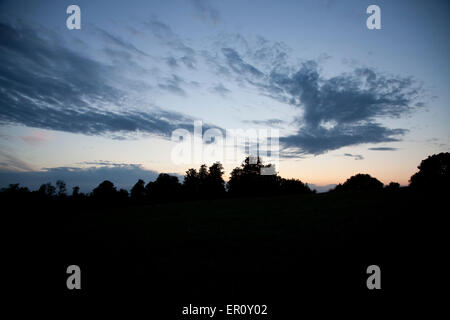 Sonnenuntergang mit wispy Cirrus-Wolken über Baum Schatten auf einem Hügel Stockfoto