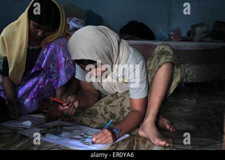 Medan, Indonesien. 24. Mai 2015. Rohingya-Flüchtlinge aus Myanmar lernen malen ein Bild in einem Buch geschrieben in Notunterkünften in Medan, Nord-Sumatra, Indonesien am 23. Mai 2015 Nachdem sie am 15. Mai in Pangkalan Susu, Indonesien von indonesischen Fischern aus Gewässern Sumetra gerettet wurden. fast 100 Rohingya Migranten aus Myanmar untergebracht waren. Drei Wellen von ethnischen Rohingya aus Myanmar und Bangladesch, die Zahl mehr als 1.700 Menschen gerettet durch ein Fischer in Aceh seit 10 bis 20 Mai 2015. Bildnachweis: Pazifische Presse/Alamy Live-Nachrichten Stockfoto