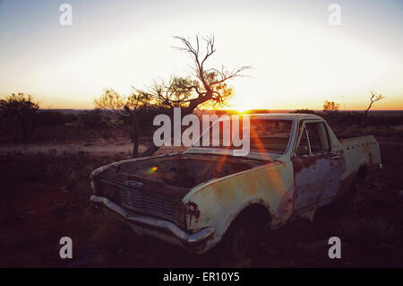 Verlassenes Auto mit dem Sonnenaufgang in der australischen Wüste. Stockfoto