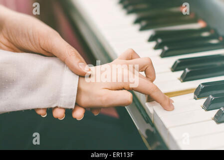 Frau unterrichtet kleine Mädchen auf das Klavier zu spielen. Stockfoto