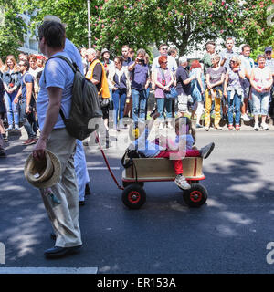 Kreuzberg, Berlin, Deutschland, 24. Mai 2015. Zwei kleine Kinder mit Ohrenschützer in Holz Wagen in die Parade als Berlin feiert seine kulturelle Vielfalt auf dem Karneval der Kulturen zu Pfingsten jedes Jahr. Das große Finale ist der Straßenumzug am Pfingstsonntag, wo Tausende von Tänzern, Musikern und Künstlern durchführen, und über 1 Million Menschen aus der ganzen Welt ansehen. Stockfoto