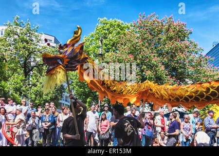 Kreuzberg, Berlin, Deutschland, 24. Mai 2015. Menschenmassen beobachten den chinesischen Drache, wie Berlin seine kulturelle Vielfalt auf dem Karneval der Kulturen zu Pfingsten jedes Jahr feiert. Das große Finale ist der Straßenumzug am Pfingstsonntag, wo Tausende von Tänzern, Musikern und Künstlern durchführen, und über 1 Million Menschen aus der ganzen Welt ansehen. Stockfoto