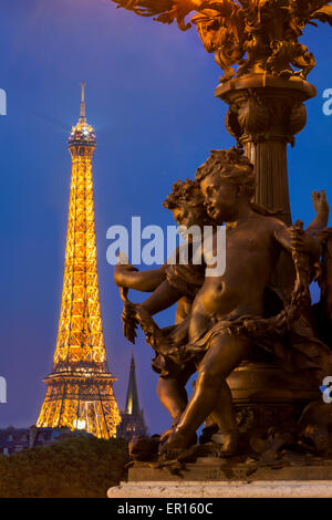 Cherub Bronzestatuen auf Laternenpfahl auf Pont Alexandre III mit Eiffelturm über Paris, Frankreich Stockfoto
